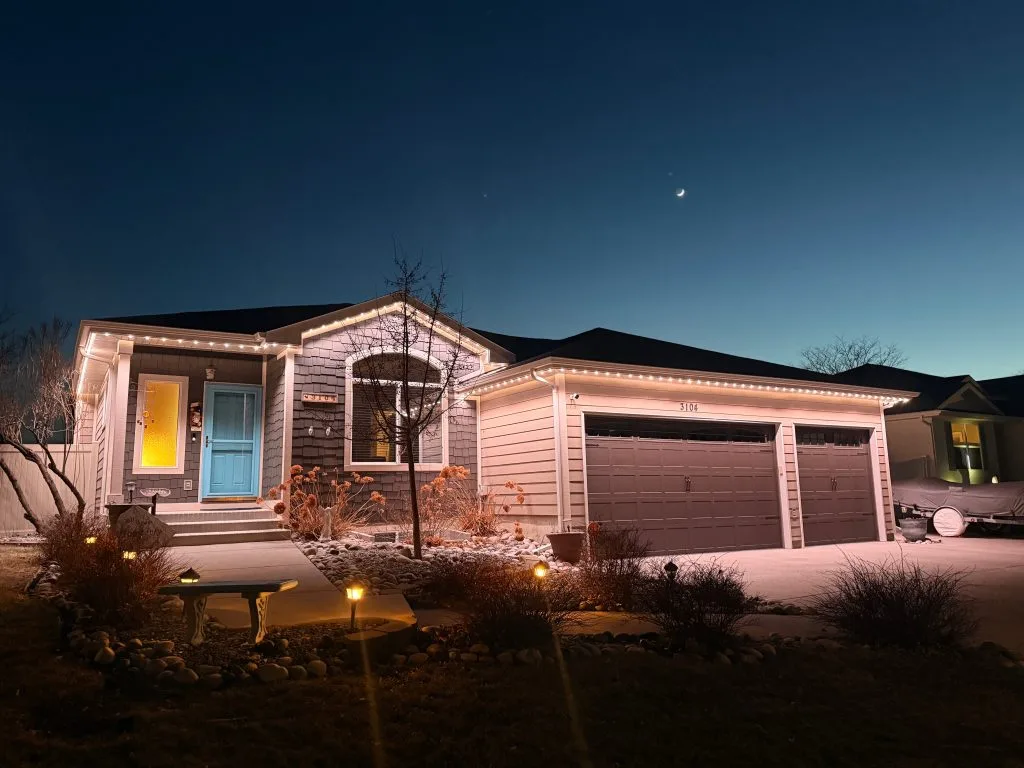 A cozy home illuminated by soft lights under a twilight sky